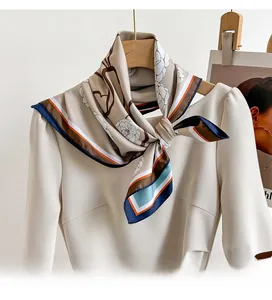Close-up of elegant twill silk scarf tied to a beige dress on a wooden hanger