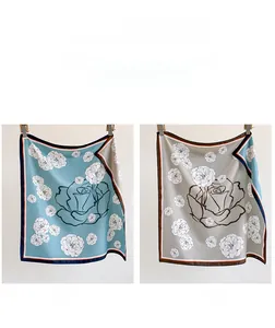 Detail view of double-sided silk scarf showing side A teal and side B grey rose prints