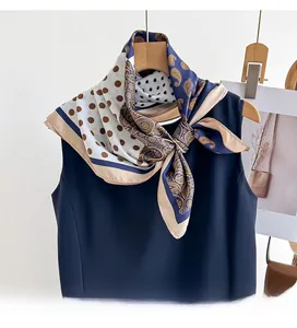 Detail of double-sided silk scarf with polka dots and paisley patterns on navy top