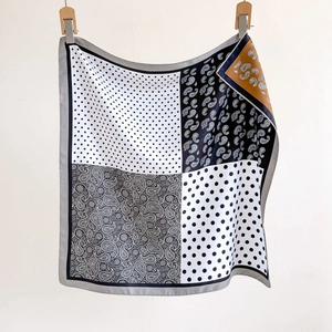 Detailed view of paisley and polka dot twill scarf featuring elegant neutral color blocking