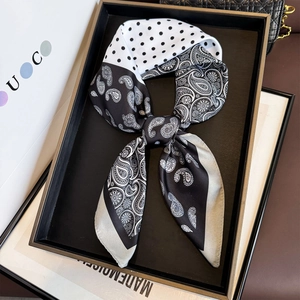 Elegant black and white silk twilly scarf with paisley and dot patterns on a gift tray