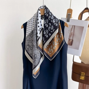 Chic twill square scarf with paisley and polka dot patterns styled on a blue dress