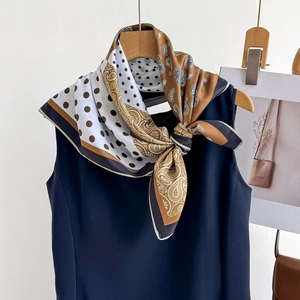 Polka dot and paisley printed silk scarf tied on a hanger with brown and navy colors