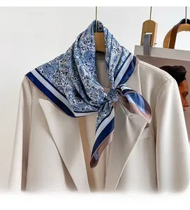 Blue paisley silk scarf in twill fabric elegantly styled on an off-white blazer collar