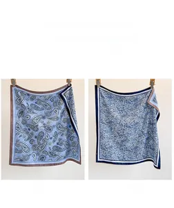 Detail of double-sided paisley twill scarf showing Side A in sky blue and Side B in grey blue