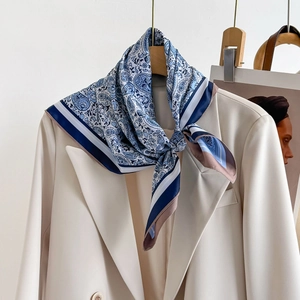 Blue and white paisley silk scarf paired with a cream blazer for a stylish look
