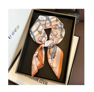 Detail view of luxury silk scarf with vintage chain patterns in a chic display