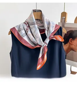 Detail of premium silk scarf with equestrian chain print tied on a navy dress