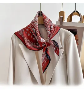 Detail of red paisley twill silk scarf tied elegantly on a beige blazer collar