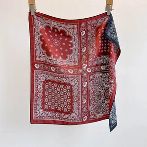 Vintage paisley silk satin scarf with red and blue pattern, hanging on white background
