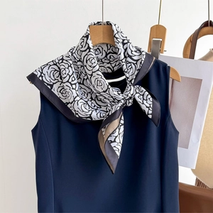 Elegant black and white floral square silk scarf styled on a navy sleeveless top