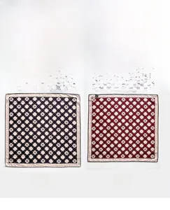 Detail view of double-sided silk wool scarf with geometric ring patterns in black and burgundy