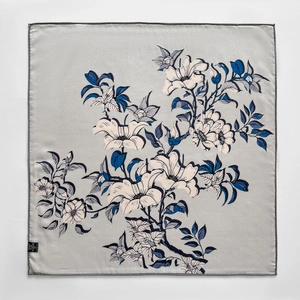 Detail of silk wool square scarf featuring elegant floral prints and fine rolled edges