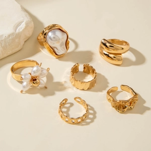 Detail of a six-piece gold ring set featuring baroque pearls and textured metal designs
