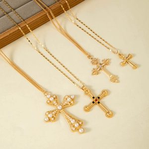 Colliers croix dorés vintage avec perles et pierres colorées sur fond beige clair