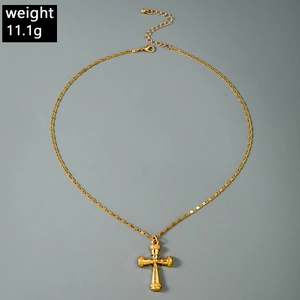 Détail du pendentif croix dorée avec texture gravée et chaîne à maillons plats de 11,1g
