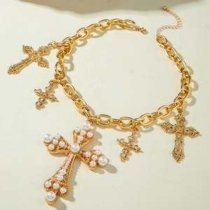 Dettaglio ravvicinato della collana a catena dorata con perle e ciondoli a croce retrò