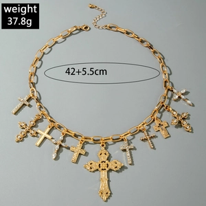 Dettaglio di ciondoli a croce vintage con cristalli scintillanti su una collana dorata