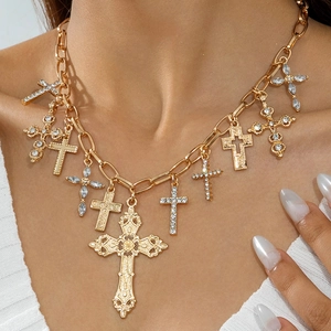 Dettaglio della collana a catena dorata con vari ciondoli a croce e strass scintillanti