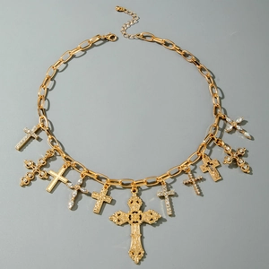 Dettaglio della collana hip-hop dorata con molteplici ciondoli a croce impreziositi da strass