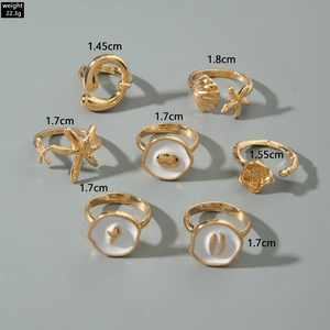 7-piece gold ocean themed ring set featuring starfish and shell designs with white enamel