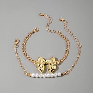 Détail d'un bracelet double couche avec nœud métallique et perles blanches nacrées