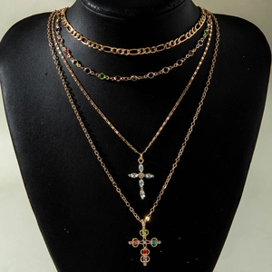 Layered gold cross necklace set with multicolored crystals and Figaro chain links
