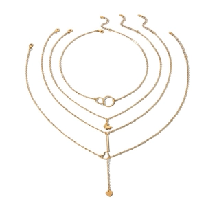 Ensemble de colliers bohèmes dorés multicouches avec pendentifs cœur et papillon sur blanc