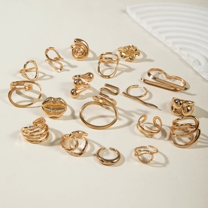 18-piece gold geometric ring set featuring lip and flower shapes on a neutral background