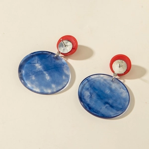 Details von blauen Marmor-Resin-Ohrringen mit kontrastierenden roten runden Steckern