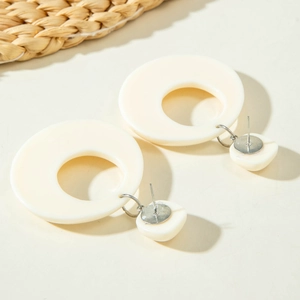 Detailansicht minimalistischer cremeweißer Acryl-Ohrringe im geometrischen Design