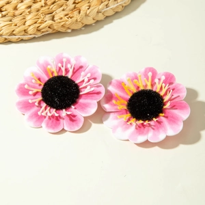 Detail of pink floral earrings featuring gradient petals and a black velvet center