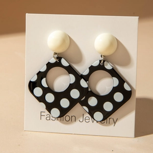 Detail von Retro-Acryl-Ohrringen mit Polka-Dots und weißem Stecker auf Displaykarte