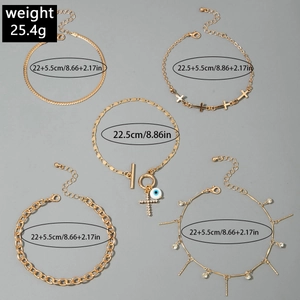 Detail of five gold-plated anklets with cross pendants and blue evil eye charms