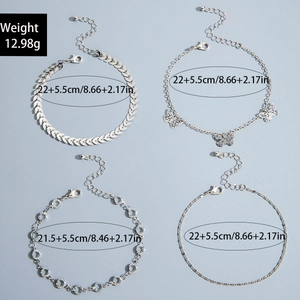 Detail view of four silver-colored anklets with leaf pattern and butterfly pendant charms