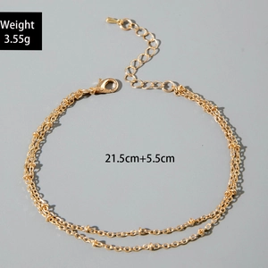Close-up of gold double-layer beaded anklet with weight and length dimensions info