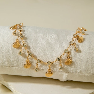Detail of gold shell pendants and sparkling crystal rhinestones on a layered anklet chain