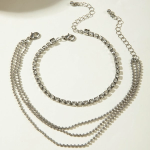 Detail of layered silver anklet featuring square rhinestones and beaded chains