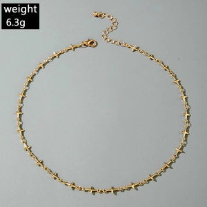 Détail du collier à pendentifs croix dorée avec fermoir mousqueton et chaîne d'extension