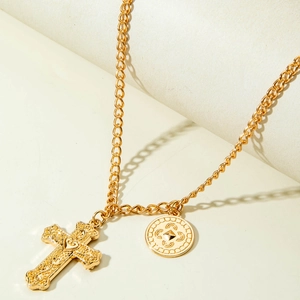 Détail du collier croix doré multicouche avec relief cœur et pendentif pièce vintage