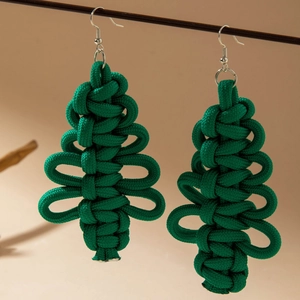 Detail of handmade green woven Christmas tree earrings with silver hooks and knot texture