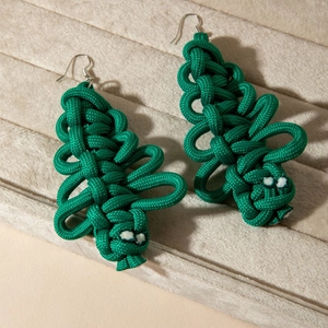 Handmade green woven Christmas tree earrings with silver hooks in a beige jewelry box