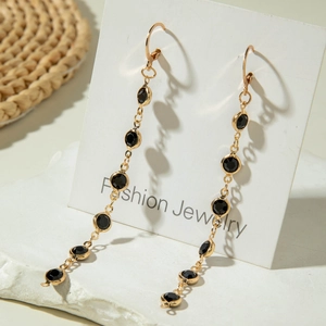 Élégantes boucles d'oreilles pendantes dorées avec cristaux noirs pour un style raffiné