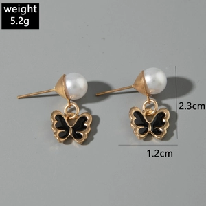 Détail de boucles d'oreilles papillon en perles, 2,3x1,2cm, avec finition noire émaillée