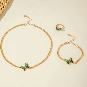 Détail d'un ensemble de bijoux dorés avec breloques papillons irisées et textures fines