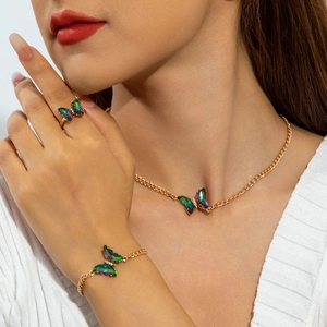 Parure bijoux dorée avec papillons irisés sur le collier, le bracelet et la bague