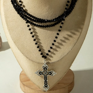 Gothic multi-layer necklace with black beads and a vintage cross pendant on display