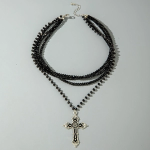 Macro view of multi-layer black beaded necklace with vintage gothic cross pendant