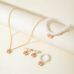 Détail d'un ensemble de bijoux papillon rose avec perles et collier doré poli