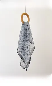 Close-up of fine overlock edge on a blue and white checkered 70cm silk-like chiffon scarf
